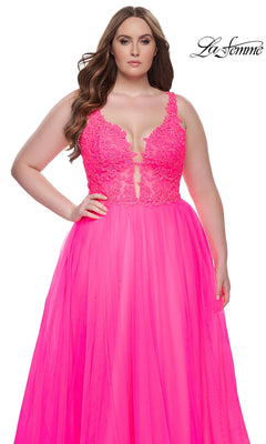 A woman wears the La Femme Long Prom Dress 31394—a bright pink gown with an embroidered lace bodice and tulle skirt—standing against a white background with the La Femme logo in the top right corner.
