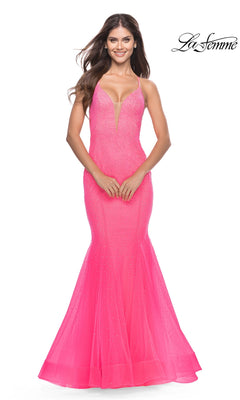 A woman wearing a neon pink, floor-length rhinestone La Femme 31407 mermaid prom dress with a deep V-neckline and embellished bodice.
