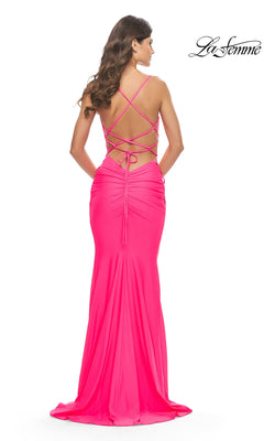 Back view of the Long Prom Dress: La Femme 31438, a floor-length, bright pink ruched jersey gown featuring a strappy open back and delicate lace-up detailing.