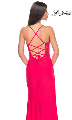 A woman stands against a white background wearing the La Femme Bright Hot Coral Long Prom Dress 31440, featuring a lace-up open back with crisscross straps. The "La Femme" logo appears in the top right corner.