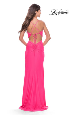 Back view of the Long Prom Dress: La Femme 31446, a floor-length hot pink jersey gown with a strappy open back, twist-knot details, and ruching at the lower back.