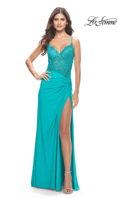 A woman in the Sheer-Bodice Long Prom Dress La Femme 31447, featuring a turquoise hue, embroidered bodice, thin straps, high slit, and ruched details, stands with one hand on her hip.