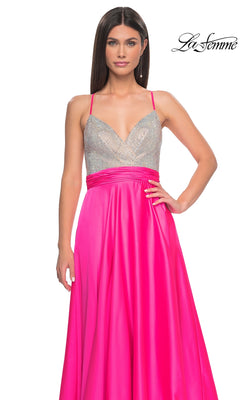 A woman poses against a white background wearing the La Femme Neon Pink Long Prom Dress 31448, which features a sleeveless beaded bodice and a bright satin skirt.
