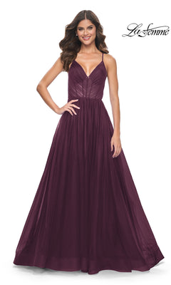 Woman poses in the La Femme Sheer-Waist Long Prom Ball Gown 31457, a sleeveless burgundy A-line dress with a fitted bodice and flowing skirt, smiling against a white background. La Femme logo appears in the top right corner.