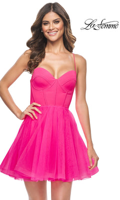A woman wearing the Hot Pink Short La Femme Homecoming Dress 31468, featuring a satin corset bodice and fitted silhouette, smiles against a white background with the "La Femme" logo.