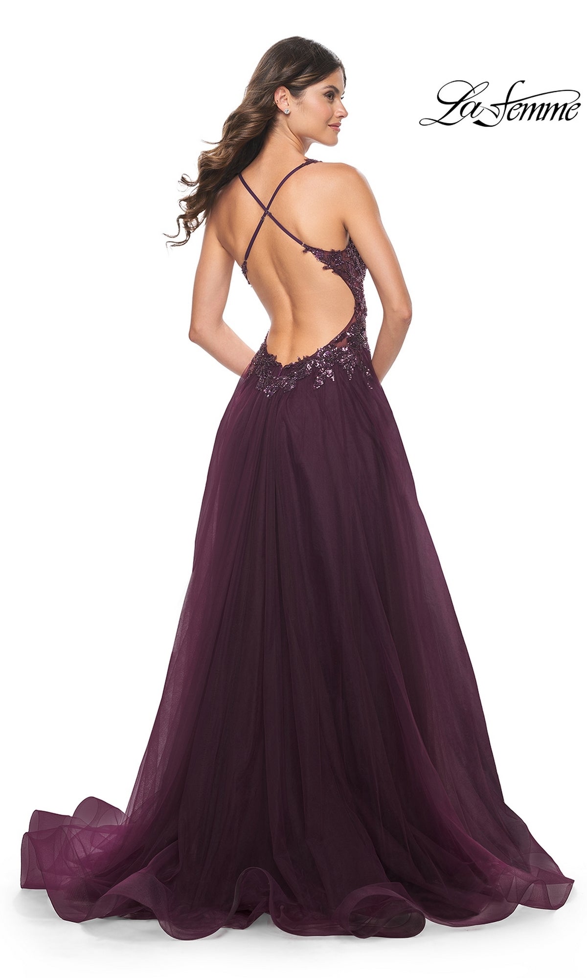 A woman models the La Femme Beaded-Bodice Long A-Line Prom Gown 31471—floor-length, deep purple with an open back, crisscross straps, and sequin waist—against a white background. La Femme logo appears in the corner.