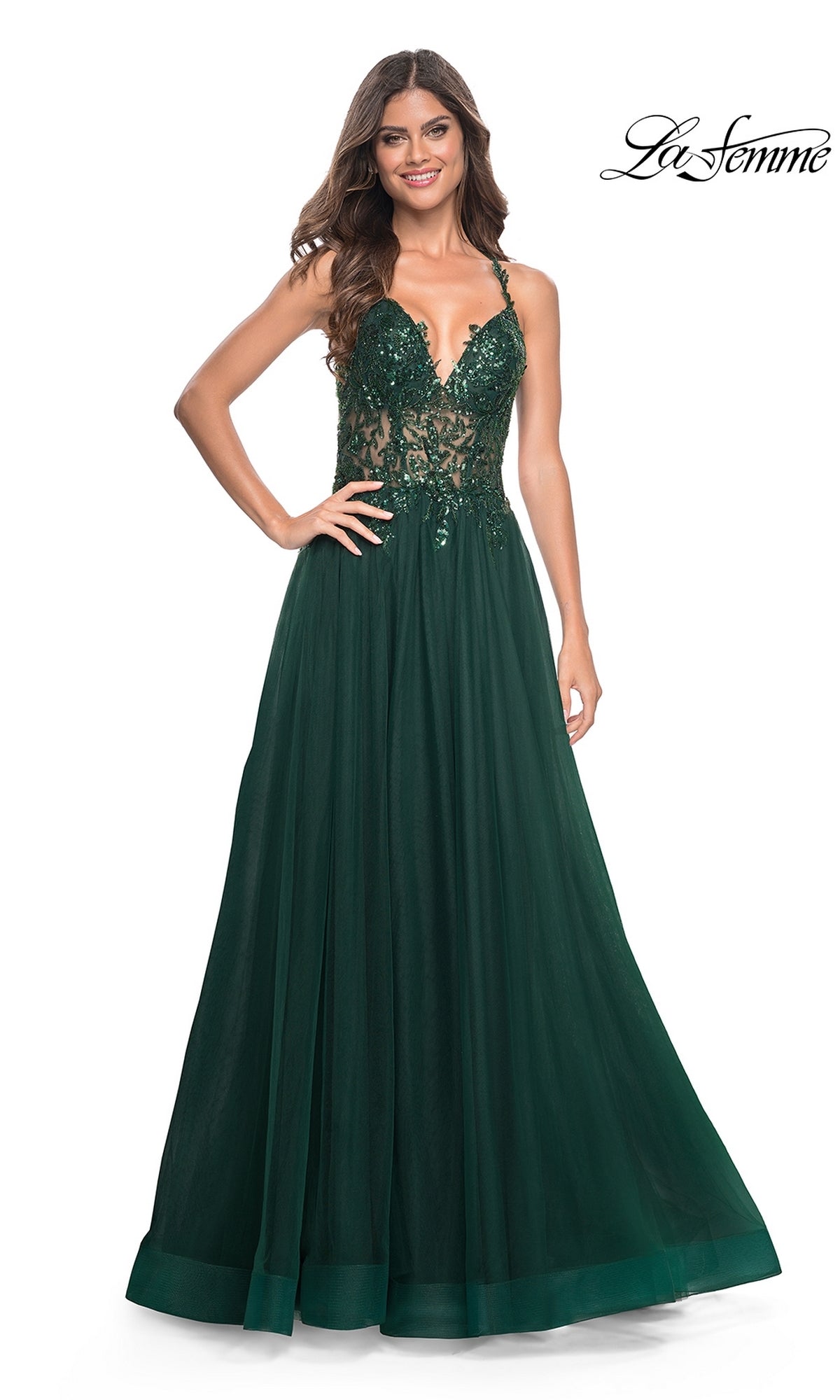 A woman wearing the La Femme Beaded-Bodice Long A-Line Prom Gown 31471 in dark green with a lace bodice and spaghetti straps stands smiling against a plain white background.