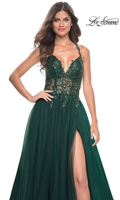 A woman wears the La Femme Beaded-Bodice Long A-Line Prom Gown 31471: a dark green, floor-length gown with a fitted sequined bodice, thin straps, high leg slit, tulle fabric, and floral embellishments for an elegant look.