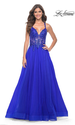 A woman smiles in the La Femme Beaded-Bodice Long A-Line Prom Gown 31471, featuring a royal blue tulle skirt and fitted beaded v-neck bodice, posing against a white background with the La Femme logo in the top right corner.