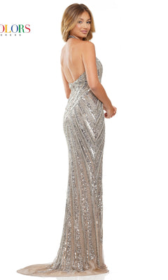 A woman stands against a white background, looking over her shoulder in the Long Halter Platinum Silver Beaded Prom Dress 3148, featuring sparkling sequins and geometric patterns.