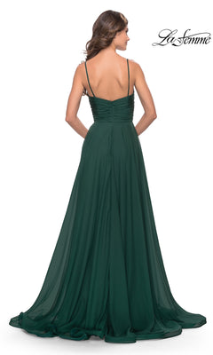 A woman in a dark green, floor-length, sleeveless La Femme V-Neck Long A-Line Prom Dress 31500 faces away, showing the gown's flowing skirt and ruched bodice. The "La Femme" logo is visible in the top right corner.