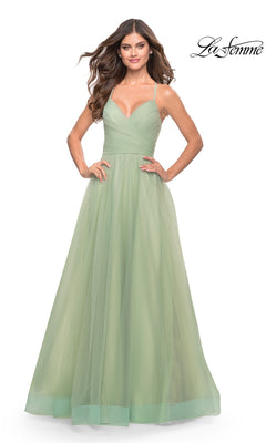 Woman wearing the La Femme Wrap-Bodice Long A-Line Prom Dress 31501 in light green, featuring spaghetti straps and a fitted bodice, standing with hands on hips against a plain white background.