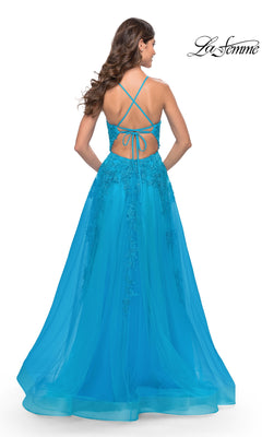 A woman in the La Femme Strappy-Back Long A-Line Prom Dress 31503, featuring a blue color, lace details, strappy-back design, and an elegant flowing tulle skirt, stands facing away from the camera.