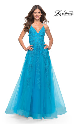 A woman wearing the La Femme Strappy-Back Long A-Line Prom Dress 31503, featuring a sleeveless blue bodice with lace detailing and a tulle skirt, smiles with hands on hips. The La Femme logo appears in the top right corner.