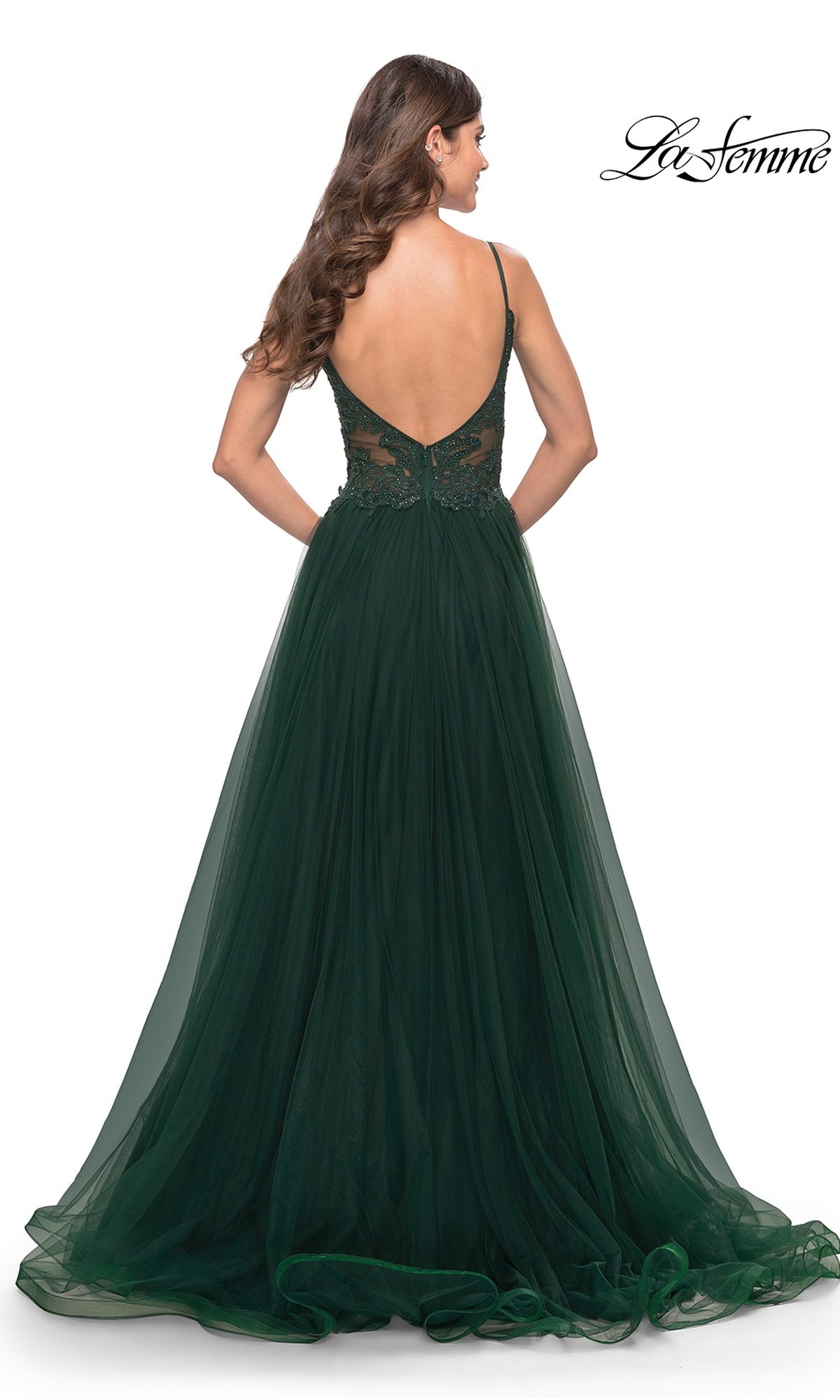 Woman wearing the Lace-Bodice Long Tulle Prom Dress: La Femme 31507 in dark green, featuring sheer lace detailing on the back, stands against a white background.