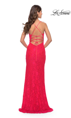 La Femme 31510 is a floor-length, bright pink lace prom dress in a fitted sheath style, featuring a strappy, lace-up open back.