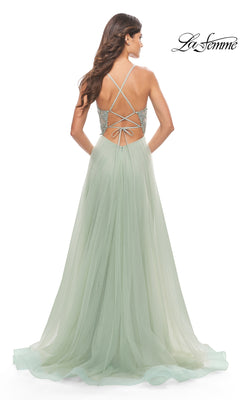 A woman is seen from behind wearing the La Femme 31542, a light green, floor-length A-line prom dress featuring an embroidered lace bodice, lace-up open back, and tulle skirt. The La Femme logo is in the top right corner.