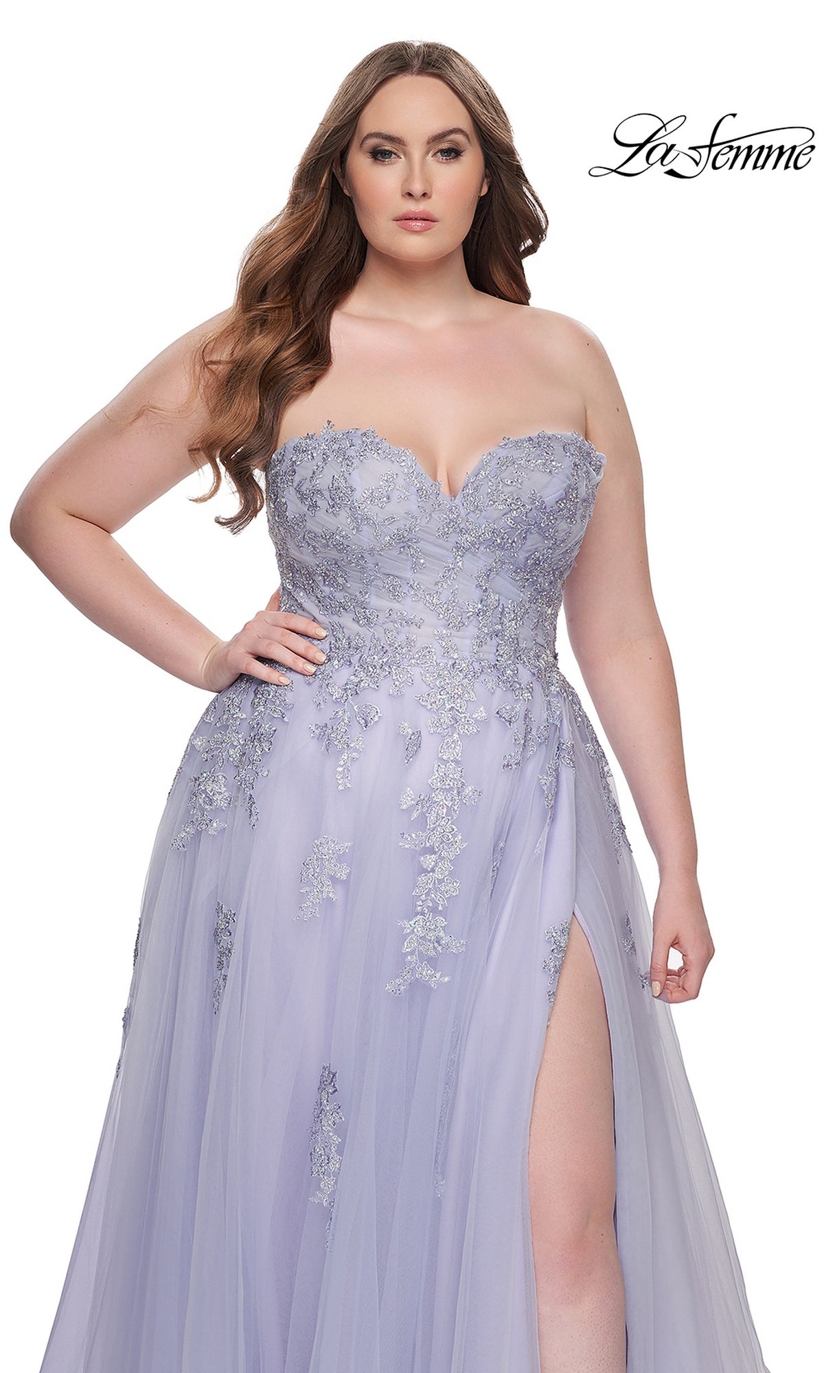 A woman models the La Femme Long Prom Dress 31570, a plus-size strapless gown with a corset bodice, silver embroidered lace, and thigh-high slit, standing against a white background. The La Femme logo appears in the upper right corner.