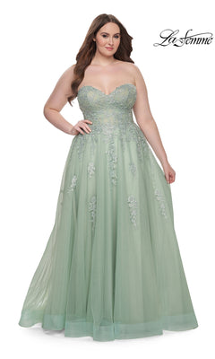 A woman poses against a white backdrop wearing the La Femme Long Prom Dress 31570, a strapless pastel green floor-length gown with a corset-style bodice and floral embroidered lace on the tulle skirt.