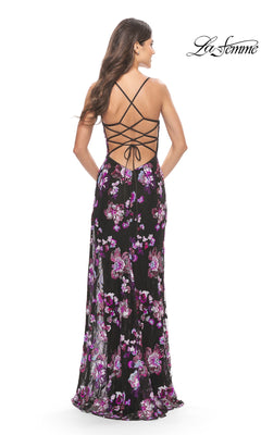 A woman wears the Floral-Print Long Black Prom Dress: La Femme 31597, featuring purple patterns and an open back with crisscross straps—perfect for making a striking prom statement.