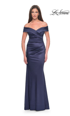 A woman wearing the Long Formal Dress: La Femme 31621, a navy, floor-length, off-the-shoulder gown in stretch-satin with a wrapped bodice.
