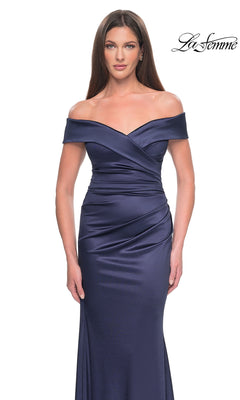A woman wears a navy blue, floor-length off-the-shoulder Long Formal Dress: La Femme 31621 with a draped, wrapped bodice.