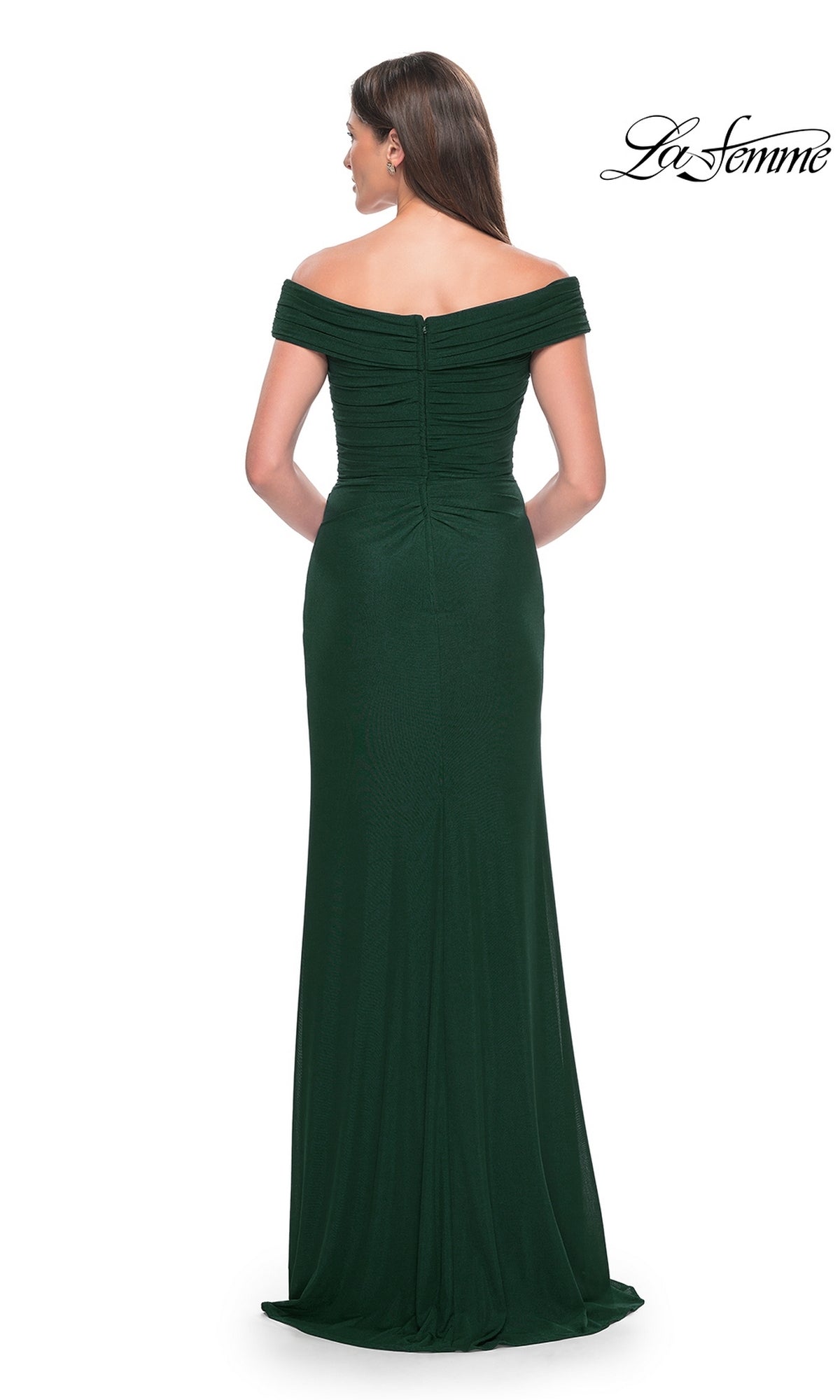 A woman wears the La Femme Off-the-Shoulder Long Prom Dress 31677 in dark green, featuring ruched detailing, a back zipper closure, and an elegant design—perfect for formal events and special occasions.