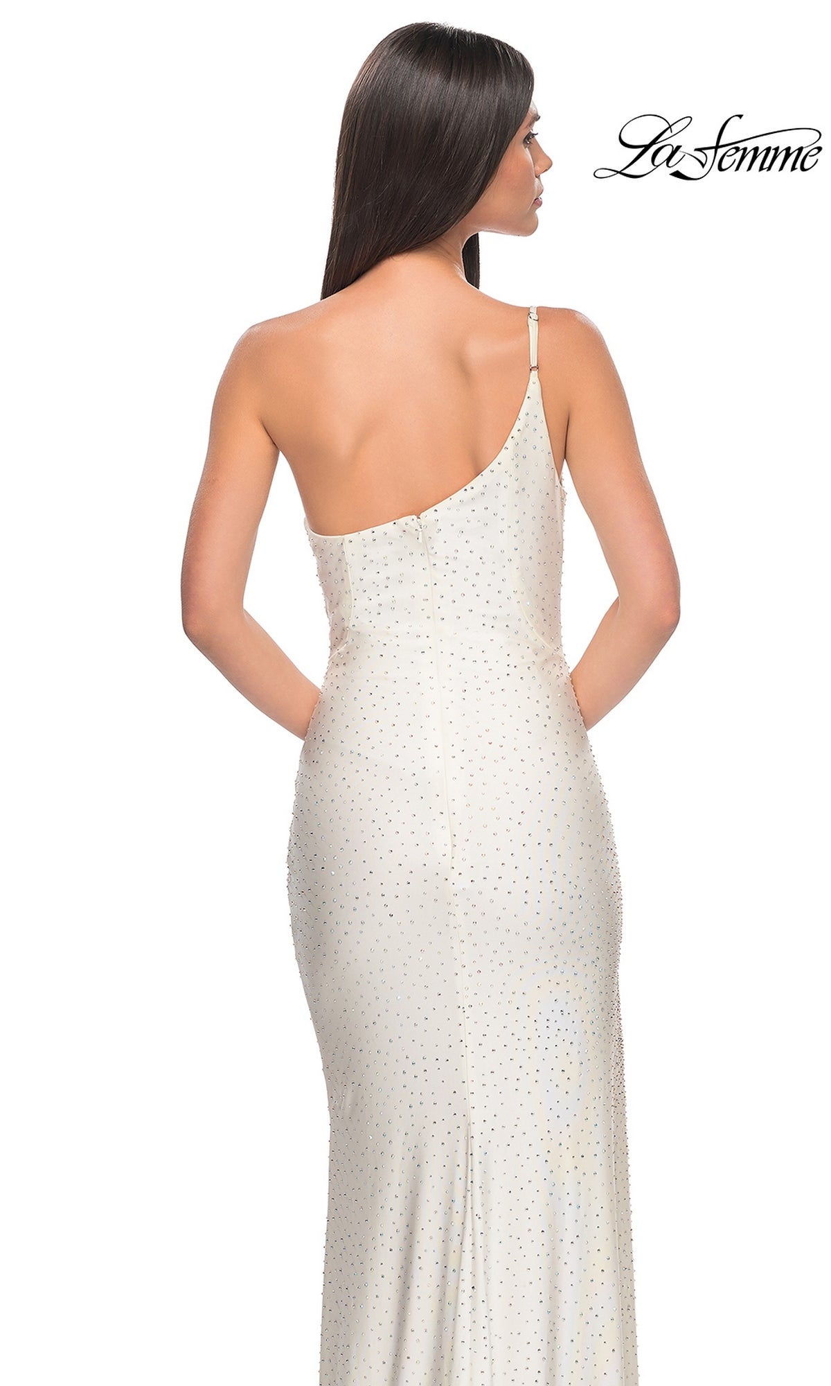 A woman with long brown hair models the La Femme Beaded One-Shoulder Long Prom Dress 31699 in off-white with rhinestone embellishments, shown from the back. The La Femme logo is visible in the top right corner.
