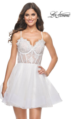 Woman wearing Sheer-Bodice Short La Femme Homecoming Dress 31769, featuring white lace and tulle, spaghetti straps, a corset bodice, fitted waist, and flared skirt. "La Femme" logo appears in the upper right corner.