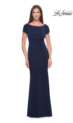 A woman wearing a floor-length navy blue La Femme 31773 formal dress with short sleeves and side ruching.