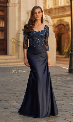 Outdoors, a woman wears the La Femme 31802 long formal dress in navy satin, featuring a beaded lace bodice and sequin-detailed sleeves.