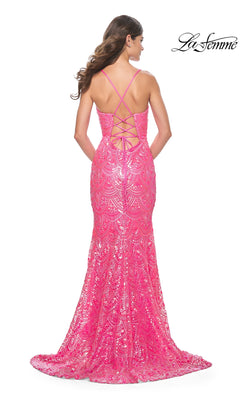 A woman wears the La Femme Sequin-Print Long Prom Dress 31865, a chic, floor-length bright pink gown with sequins, lace detailing, a strappy open back, and a slight train—elegant for making an entrance. "La Femme" logo in the top right corner.