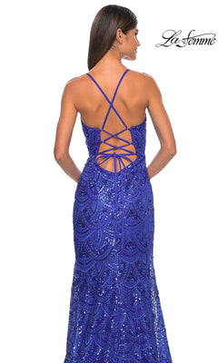 A woman stands facing away in the La Femme Sequin-Print Long Prom Dress 31865, a royal blue gown with sparkling sequins and a crisscross lace-up open back. La Femme logo appears in the top right corner.