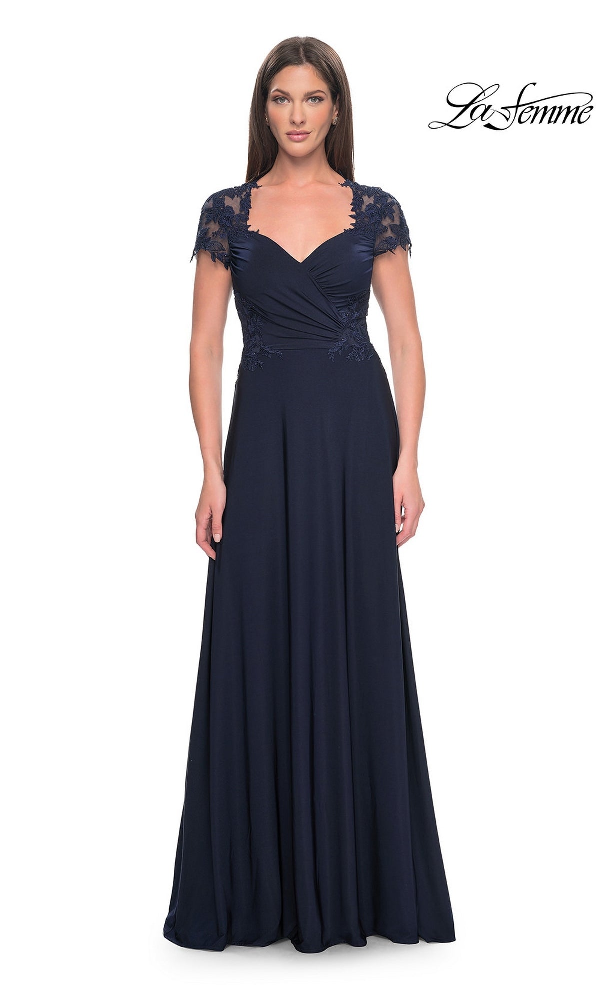 A woman wearing the La Femme Cap Sleeve Long Purple Prom Dress 31906 in navy, featuring lace short sleeves and a fitted bodice, stands against a plain white background. This elegant long A-line formal dress highlights classic sophistication, with the La Femme logo displayed in the top right corner.
