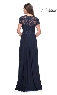 Woman in a floor-length La Femme Cap Sleeve Long Purple Prom Dress 31906, featuring sheer floral lace detailing on the back and short sleeves, standing and facing away from the camera.