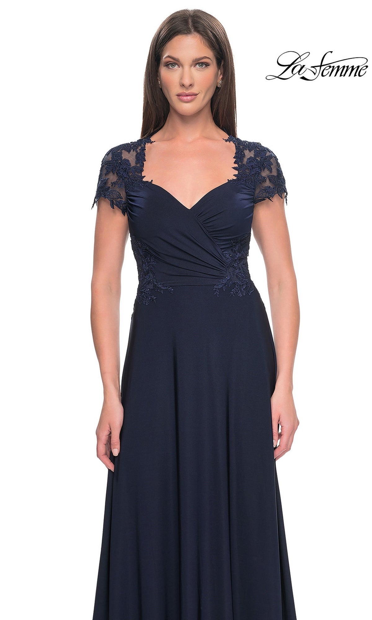 A woman wearing the La Femme Cap Sleeve Long Purple Prom Dress 31906, featuring lace cap sleeves and a sweetheart neckline, stands against a white background.