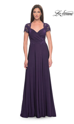 A woman wears the La Femme Cap Sleeve Long Purple Prom Dress 31906, featuring lace cap sleeves, a sweetheart neckline, ruched bodice, and a flowy floor-length skirt. The "La Femme" logo appears in the top right corner.
