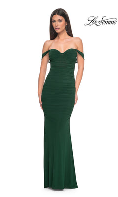A woman poses against a plain white background in the La Femme Off-the-Shoulder Long Prom Dress 31914, a fitted dark green gown with ruched detailing. The "La Femme" logo appears in the top right corner.