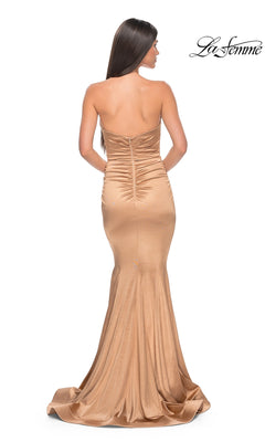 A woman is shown from the back in the La Femme Strapless Ruched Long Prom Dress 31915, a fitted gold mermaid-style gown with ruched detailing and a strapless neckline. The La Femme logo appears in the top right corner.