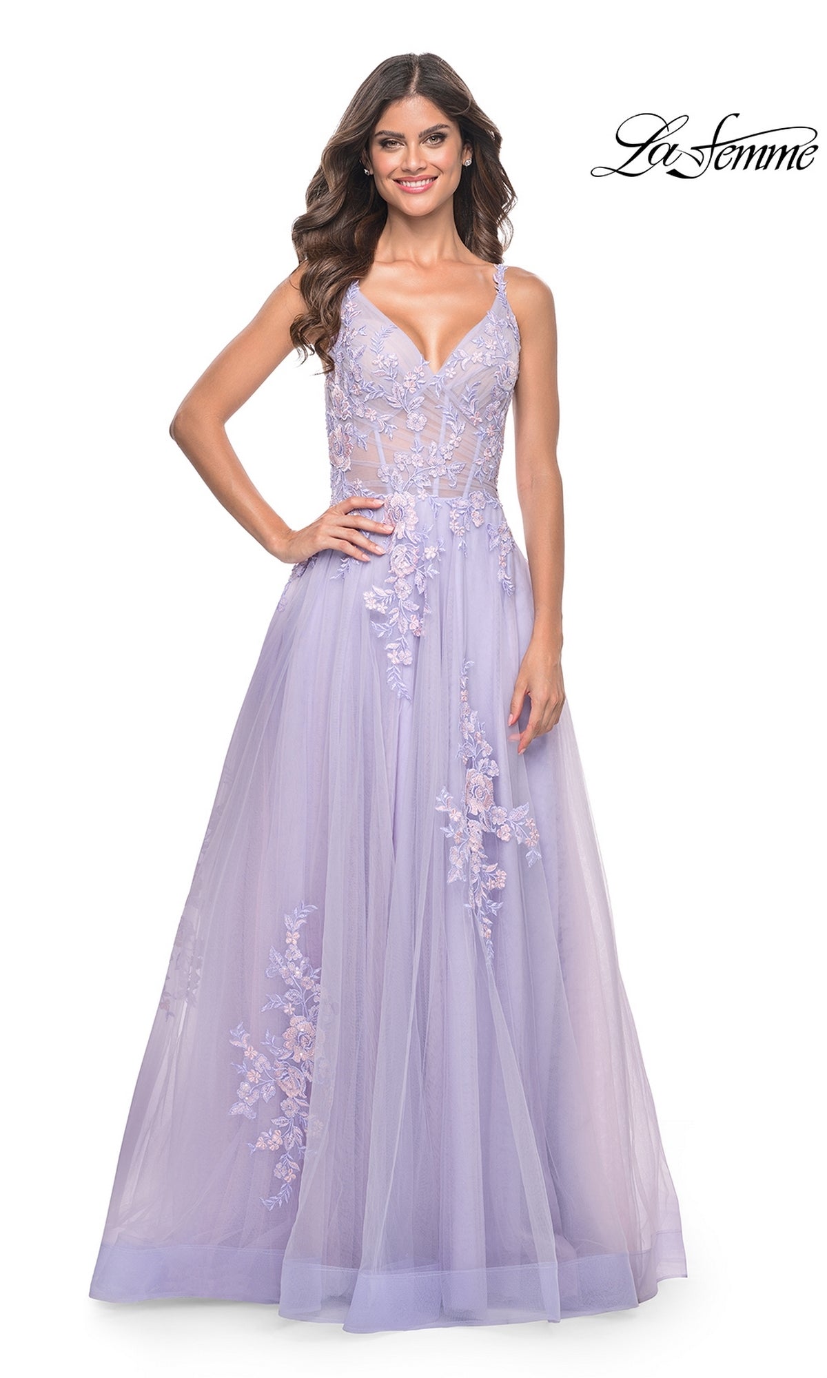 A woman wears the La Femme Embroidered-Lace Long Prom Dress 31939, a lavender floor-length gown with floral details, sheer bodice, and spaghetti straps, standing against a white background. 
