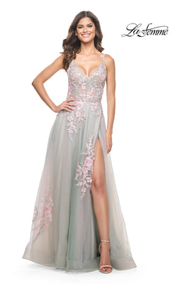 A woman smiles with one hand on her hip, wearing the La Femme Embroidered-Lace Long Prom Dress 31939—a sleeveless, floor-length gown with pink floral lace details and a thigh-high slit. The "La Femme" logo is shown in the top right.