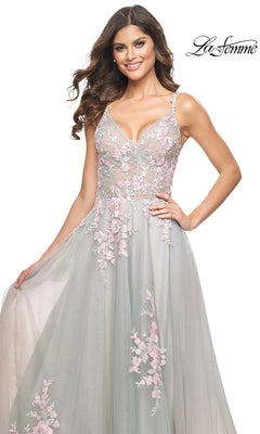 A woman smiles as she holds the side of her skirt, wearing the La Femme Embroidered-Lace Long Prom Dress 31939 in light green with pink floral details. "La Femme" logo appears in the top right corner.