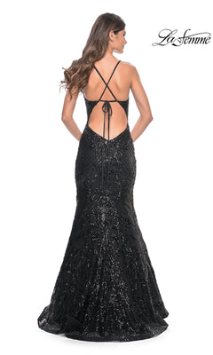Woman wears the La Femme Sequin-Print Long V-Neck Prom Dress 31943, a black floor-length gown with a low back, crisscross straps, mermaid skirt; she stands facing away. "La Femme" logo in top right corner.