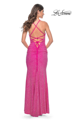 Woman wearing the La Femme Cowl-Neck Long Beaded Prom Dress 31968, a fitted, floor-length pink gown with a crisscross open back, standing and facing away from the camera. "La Femme" logo appears in the top right corner.