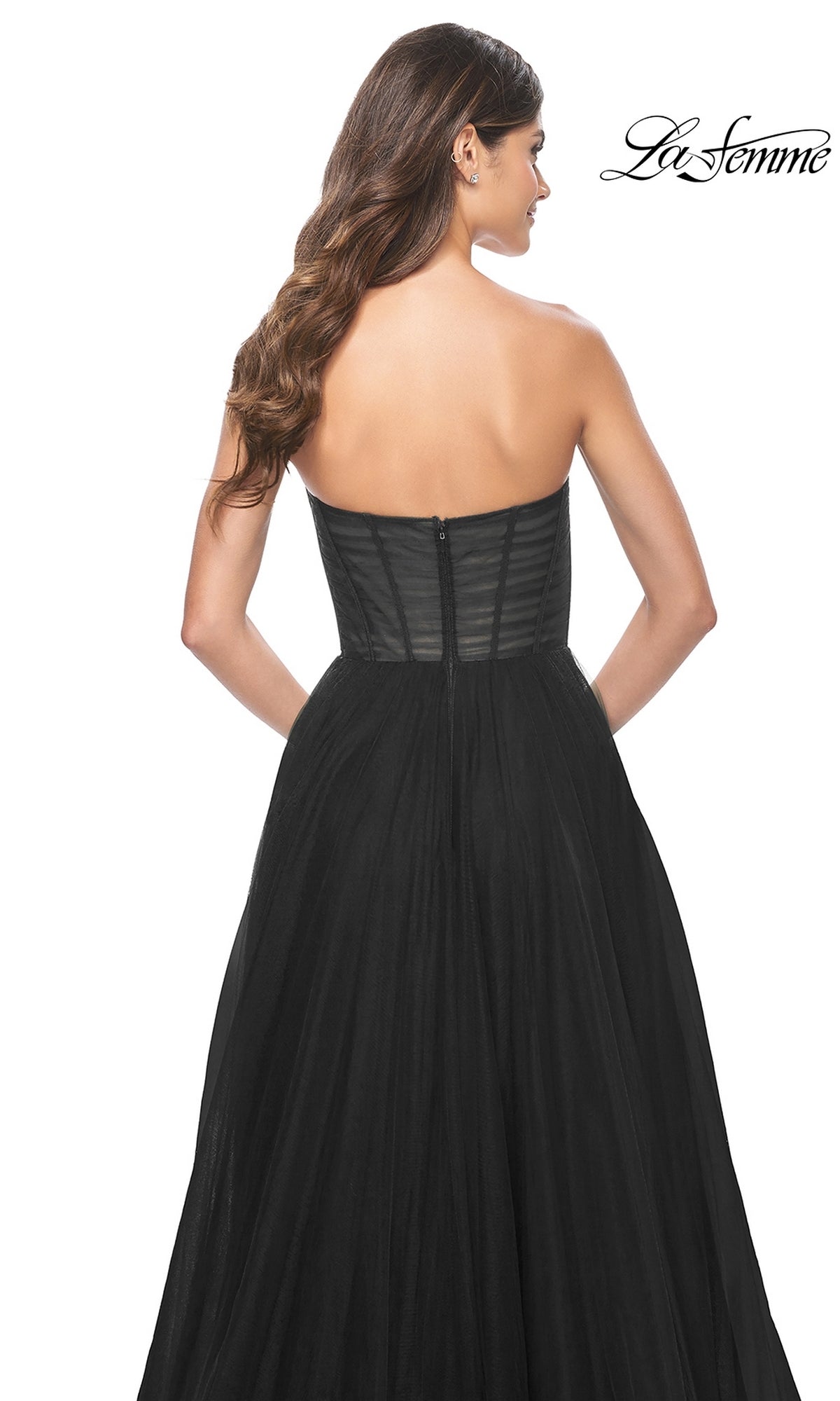 Woman in the La Femme Strapless Long A-Line Prom Dress 31971, featuring a strapless black floor-length design with a fitted bodice and flowing skirt, shown from the back against a white background.