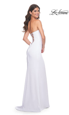 A woman smiles over her shoulder in the La Femme Bead-Trim Strapless Long Prom Dress 31977, featuring a lace-up back and beaded sweetheart neckline, against a plain background. "La Femme" prom dress logo appears in the top right corner.