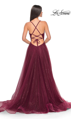 A woman stands with her back to the camera, showcasing the La Femme Long Sequin A-Line Prom Dress 31986—a floor-length gown with crisscross straps and a shimmery tulle skirt, perfect for formal occasions.