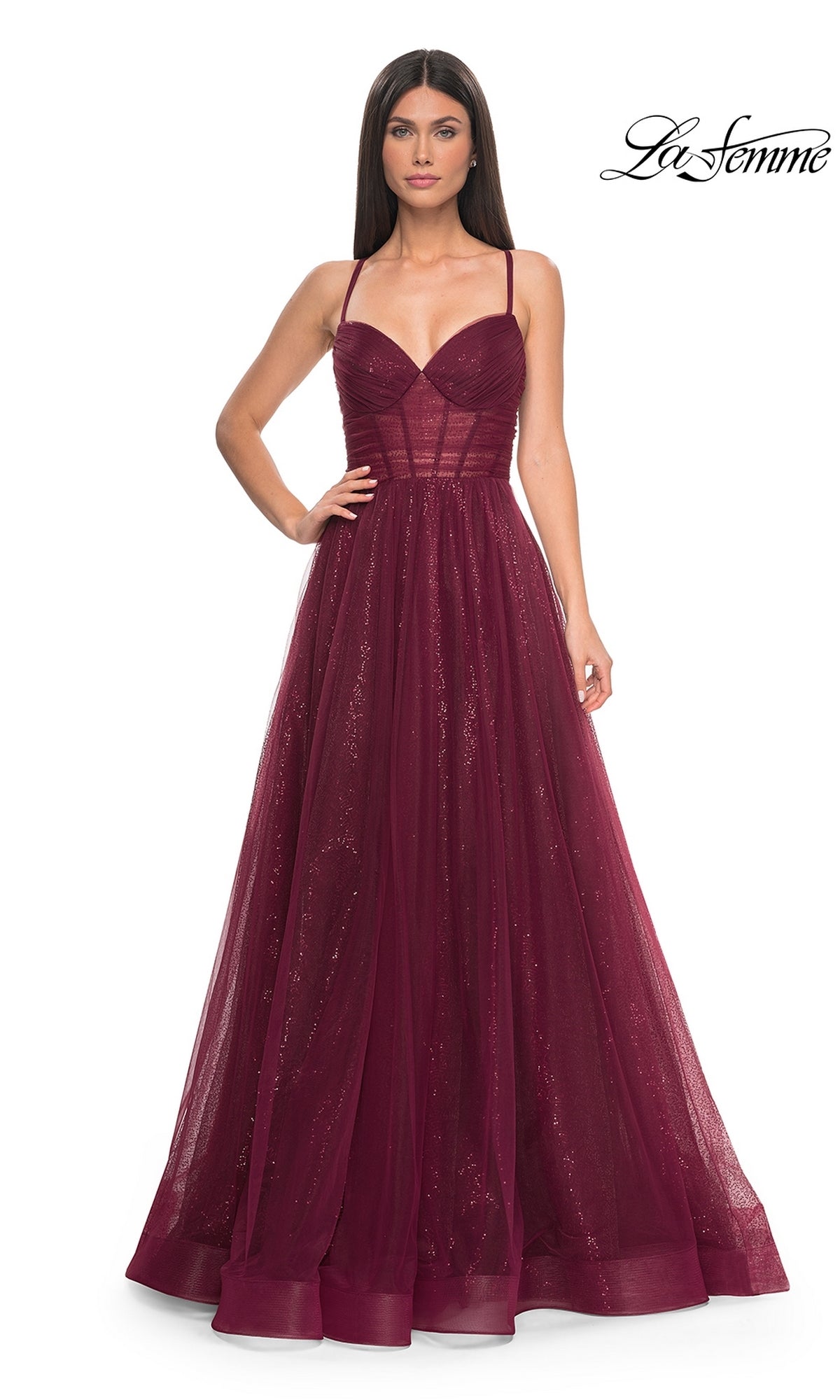 Woman in a sleeveless La Femme Long Sequin A-Line Prom Dress 31986 with a fitted bodice and tulle skirt, standing against a plain white background.