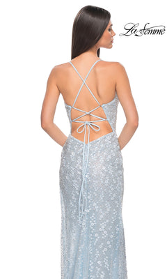 Woman models the Strappy-Back Long La Femme Beaded Prom Dress 31993, featuring light blue fabric, crisscross straps, and an open back, with her back facing the camera.