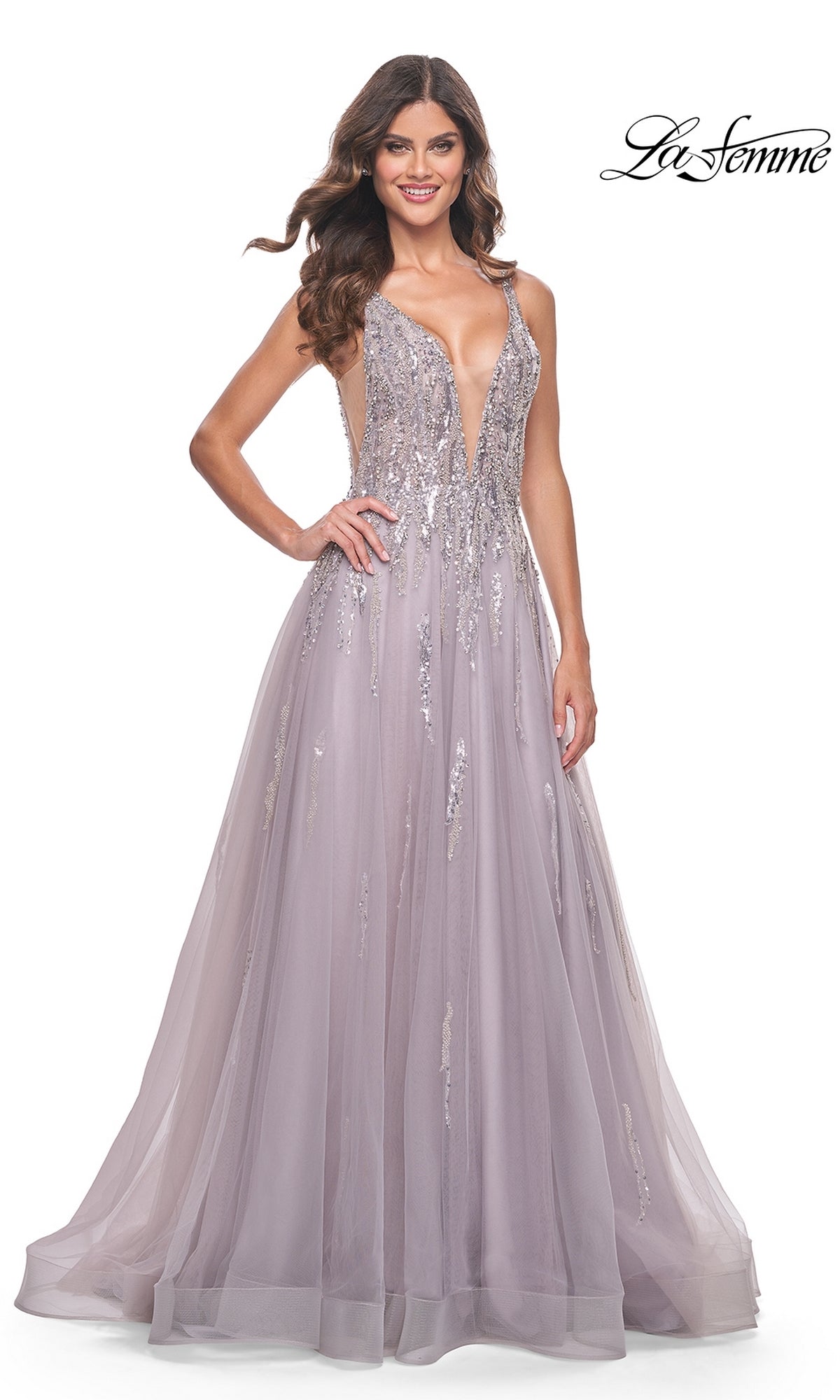 A woman in the Sequined Long Mauve Prom Dress: La Femme 31995, featuring a deep V neckline, sequin details, and a flowing tulle skirt, stands against a white background.